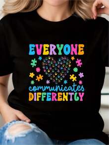 Camiseta gráfica de algodón negro de 180 g, cuello redondo y manga corta. "Todos nos comunicamos de manera diferente". Camiseta inspiradora con diseño de corazón y rompecabezas para mujer. Top informal colorido con mensaje positivo. - Negro - Ver 2