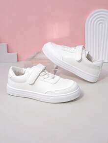 زوج من أحذية رياضية بيضاء بسيطة ذات لون أحادي من مواد ناعمة وقابلة للتنفس بأصابع مستديرة وكعب منخفض للاستخدام اليومي والمدرسة