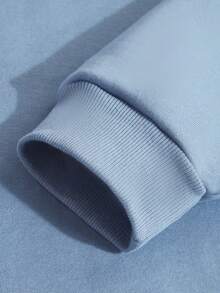 Moletom feminino solto. Um moletom com um tubarão com dentes amarelos e língua rosa espirrando nas ondas de água acima do tubarão. A frase "Helluva Time" está escrita em uma impressão internacional.