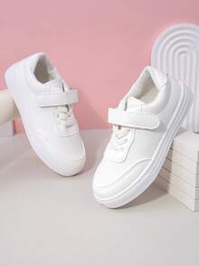 زوج من أحذية رياضية بيضاء بسيطة ذات لون أحادي من مواد ناعمة وقابلة للتنفس بأصابع مستديرة وكعب منخفض للاستخدام اليومي والمدرسة