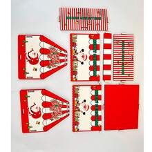 Uma pequena caixa de armazenamento de madeira com um padrão de desenho animado de um Papai Noel colorido entregando presentes, série de montagem DIY não concluída.