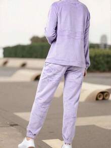 Un clásico conjunto de pijama de felpa para mujer con una camiseta de manga larga, cuello redondo y puños ligeramente ajustados. Los pantalones rectos con puños ligeramente ajustados y cintura natural están confeccionados en poliéster, algodón y elastano. Suave y ligero, es cálido al tacto, ideal para otoño e invierno. - Morado - Ver 2