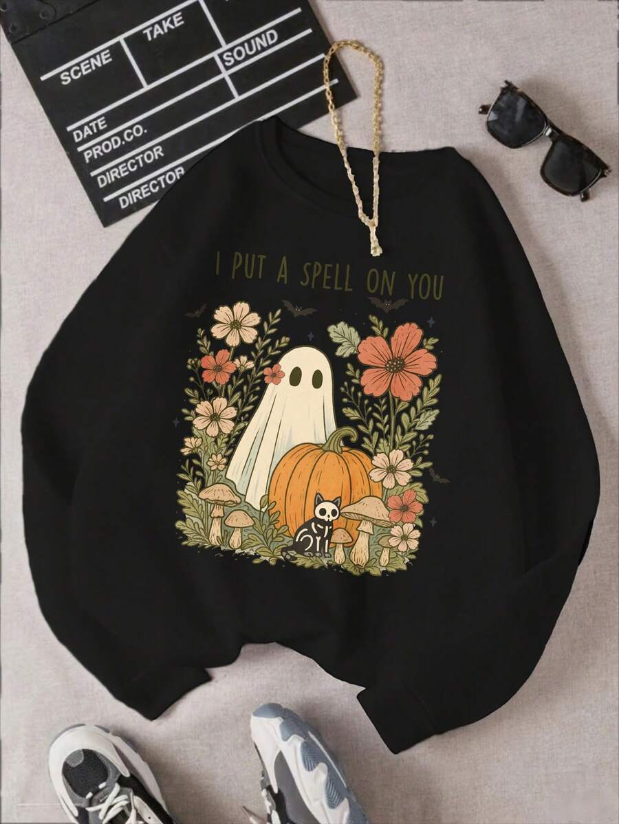 L'image principale présente un motif de produit avec un fantôme arborant une expression amicale tenant une citrouille, entouré de fleurs colorées et de champignons. Le texte au-dessus indique "I Put A Spell On You" en lettres blanches. Le fond noir fait ressortir les éléments de manière éclatante. Le design incorpore des éléments d'Halloween comme le fantôme et la citrouille tout en gardant un aspect accueillant. - Noir - Voir 1