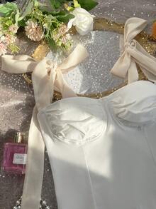 Top corto de mujer de un solo pieza, con diseño elegante y casual, hombros descubiertos, sin mangas, con detalles de lazo y silueta que favorece la figura