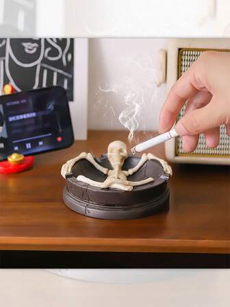 骷髅卧式烟灰缸，上班族懒人款烟灰缸，骷髅躺在烟灰缸里，仿佛在说“把你的烦恼和灰烬交给我吧~”当你把香烟放在骷髅旁边时，灰烬就会静静地落下，就像看着小骷髅身临其境地接收灰烬一样，搞笑又减压，瞬间在桌面上营造出一个暗黑可爱的小场景，烟民朋友们一定会惊呼“这也太好玩了吧！”