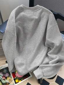 Um mundo cheio de rosas Seja um girassol O moletom apresenta um design de girassol amarelo brilhante com pétalas irradiando para fora O texto é organizado em um padrão circular ao redor do girassol em fonte preta contra o fundo bege do moletom O estilo geral é casual e confortável Perfeito para uso diário A impressão transmite uma pose