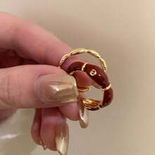 1pc Exquisite 18K Gold Plated Ring Features A Unique Irregular Flower Design With Vibrant Red Enamel Accents That Create A Striking Visual Appeal. The Open End Design Allows For Adjustable Sizing And Comfortable Stacking With Other Rings. Crafted With Premium Hypoallergenic Materials That Resist Tarnishing And Maintain Their Beautiful Appearance Through Regular Wear. The Artistic Floral Motif Combines Elegant Styling With A Touch Of Vintage Charm, Making It Suitable For Both Casual And Formal Occasions. Perfect For Adding A Pop Of Color To Your Everyday Outfits Or Making A Statement At Special Events Like Weddings, Parties, And Music Festivals. The Durable Enamel Coating Ensures Long-Lasting Color Vibrancy While Being Easy To Clean. An Excellent Gift Choice For Fashion-Forward Women Who Appreciate Unique Jewelry Designs.