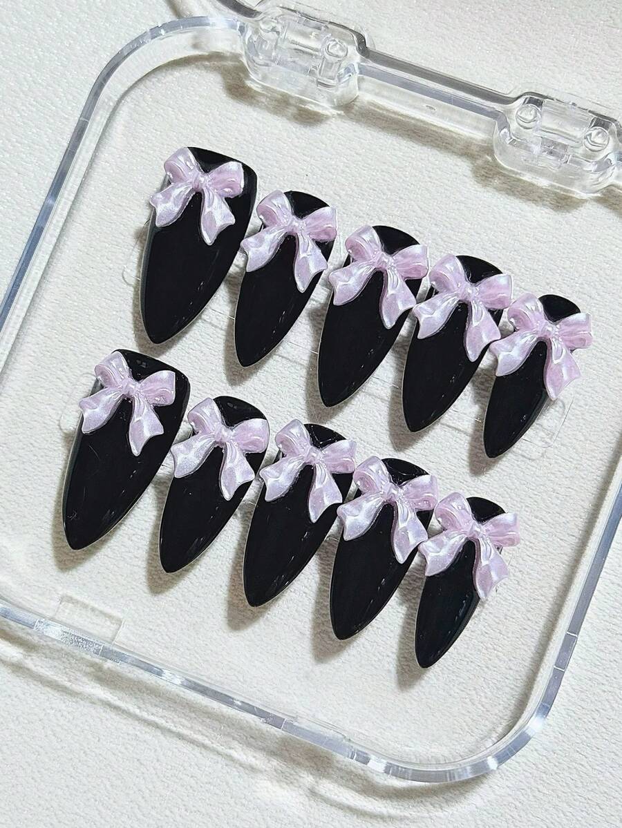 Stilul dulce și cool prezintă unghii presate în formă de migdală, de lungime medie, din zece bucăți, unghii negre, asociate cu o fundă roz-violet. Este simplu și elegant, rafinat și luxos, cu o purtabilitate de înaltă calitate. Potrivit pentru ocazii precum petreceri, întâlniri, sărbători, utilizare zilnică etc. Adaugă o notă de eleganță. Sunt incluse o bucată de lipici jeleu și o pilă de unghii mini, care pot fi detașate și reutilizate.