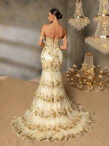 Faeriesty Chiếc đầm dạ hội trễ vai thanh lịch này nổi bật với họa tiết thêu vàng tinh tế, kiểu dáng đuôi cá và thiết kế thắt eo, rất phù hợp để tham dự các buổi dạ tiệc sang trọng, đám cưới, dạ hội từ thiện, lễ trao giải và các sự kiện trang trọng khác. - Rượu sâm banh - Xem 2