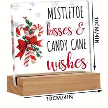 Articole decorative de Crăciun, inclusiv ornamente din acadele pentru casă, sărutări și urări cu tematică de vâsc, afișate pe semne și plăcuțe de birou din acril.