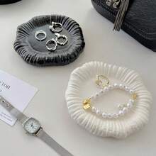 Una bandeja de joyería con forma irregular y floral, hecha a mano de cerámica cocida en horno, disponible en blanco clásico y negro elegante. Diseñada perfectamente para consolas de entrada, organiza tu joyería de manera eficiente mientras sirve como una pieza decorativa artística.