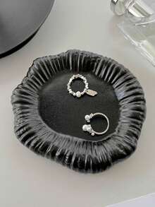 Una bandeja de joyería con forma irregular y floral, hecha a mano de cerámica cocida en horno, disponible en blanco clásico y negro elegante. Diseñada perfectamente para consolas de entrada, organiza tu joyería de manera eficiente mientras sirve como una pieza decorativa artística.