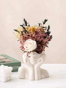 O vază cu design artistic, în formă de femeie cu mâinile care îi cuprind fața. Este simplă, dar elegantă, cu un design unic și fermecător în formă de față cu mâinile. Ideală pentru aranjarea florilor proaspete sau artificiale și poate fi folosită și pentru depozitarea cosmeticelor. Potrivită pentru decorarea camerelor de zi și a dormitoarelor pe tot parcursul anului, un element indispensabil pentru decorul zilnic al casei.