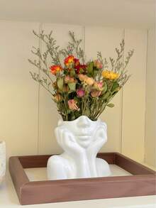 O vază cu design artistic, în formă de femeie cu mâinile care îi cuprind fața. Este simplă, dar elegantă, cu un design unic și fermecător în formă de față cu mâinile. Ideală pentru aranjarea florilor proaspete sau artificiale și poate fi folosită și pentru depozitarea cosmeticelor. Potrivită pentru decorarea camerelor de zi și a dormitoarelor pe tot parcursul anului, un element indispensabil pentru decorul zilnic al casei.