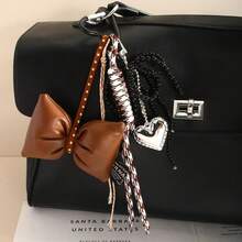 A DIY Bow-Shaped Hanging Ornament With Braiding And Heart Combination Decorations, Very Unique, Available In Multiple Colors. It Can Be Used As A Hanging Accessory In Cars, A Decoration For Women's Handbags, Bag Accessories, Backpack Accessories, Keychain Hangers, Personalized Gifts, Gifts For Children, Halloween, Birthdays, Back-To-School, Travel Souvenirs, Party Gatherings, Couple Gifts, And Wedding Gifts.