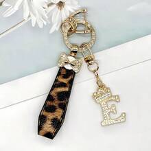 Breloc din aliaj de zinc, 1 bucată, cu design din piele PU imprimată, împreună cu un pandantiv strălucitor cu literă în formă de coroană, strat antirugină, potrivit pentru agățarea cheilor mașinii, cheilor etc. Se potrivește cu orice și este un accesoriu indispensabil pentru a purta!