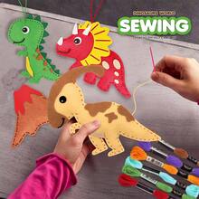 Kit de costura creativo del mundo de los dinosaurios para niños, juguete de manualidades interactivo entre padres e hijos de tela no tejida. El kit incluye varios materiales de tela no tejida con formas de dinosaurios y agujas de plástico. Los padres pueden guiar a los niños a aprender costura básica y hacer juntos Triceratops, Spinosaurus, etc., mejorando las habilidades motoras finas de los niños y el vínculo entre padres e hijos.