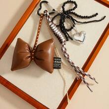 A DIY Bow-Shaped Hanging Ornament With Braiding And Heart Combination Decorations, Very Unique, Available In Multiple Colors. It Can Be Used As A Hanging Accessory In Cars, A Decoration For Women's Handbags, Bag Accessories, Backpack Accessories, Keychain Hangers, Personalized Gifts, Gifts For Children, Halloween, Birthdays, Back-To-School, Travel Souvenirs, Party Gatherings, Couple Gifts, And Wedding Gifts.