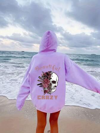 大码女式日常连帽长袖卫衣，白色骷髅头搭配深粉色玫瑰羽毛，粉色字母印有“Beautiful”和“CRAZY”字样，休闲百搭，适合春夏秋季穿着。这款大码女式长袖连帽卫衣，也是感恩节外出、度假等场合的理想之选。