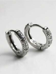 Un par de pendientes de hombre de un solo diseño, con un estilo retro y único de crisantemo en color negro, son accesorios de moda