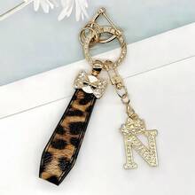 Breloc din aliaj de zinc, 1 bucată, cu design din piele PU imprimată, împreună cu un pandantiv strălucitor cu literă în formă de coroană, strat antirugină, potrivit pentru agățarea cheilor mașinii, cheilor etc. Se potrivește cu orice și este un accesoriu indispensabil pentru a purta!