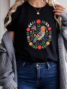 Camiseta con Estilo de Bordado Otomí Mexicano, Pájaros y Flores, diseño que honra el arte indígena otomí: pájaros con plumas decoradas y flores en patrones geométricos típicos, colores vibrantes (rojo, azul, amarillo) que siguen la tradición otomí, ajuste unisex y materiales orgánicos, perfecta para quienes quieren apoyar la cultura indígena - Negro - Ver 1