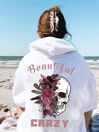 大码女式日常连帽长袖卫衣，白色骷髅头搭配深粉色玫瑰羽毛，粉色字母印有“Beautiful”和“CRAZY”字样，休闲百搭，适合春夏秋季穿着。这款大码女式长袖连帽卫衣，也是感恩节外出、度假等场合的理想之选。