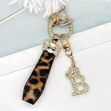 Breloc din aliaj de zinc, 1 bucată, cu design din piele PU imprimată, împreună cu un pandantiv strălucitor cu literă în formă de coroană, strat antirugină, potrivit pentru agățarea cheilor mașinii, cheilor etc. Se potrivește cu orice și este un accesoriu indispensabil pentru a purta!