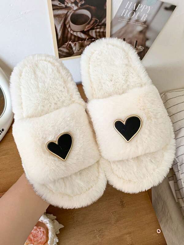 Ein Paar schwarze Mädchen Hausschuhe mit herzförmiger Knopfverzierung und dicker Sohle, einfacher Stil geeignet für den täglichen Innenbereich.