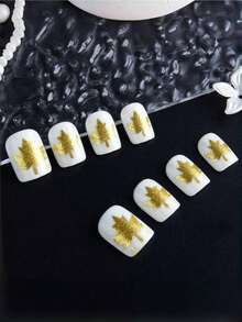 24 piezas de uñas cortas de forma cuadrada, con una base blanca y un diseño de lentejuelas doradas con hojas de arce en la temporada de otoño. Este es un arte de uñas ultra brillante que mejora la atmósfera. Es un set de arte de uñas adecuado para citas de mujeres, uso diario, reuniones y trabajo. ¡Puede realzar tu encanto!