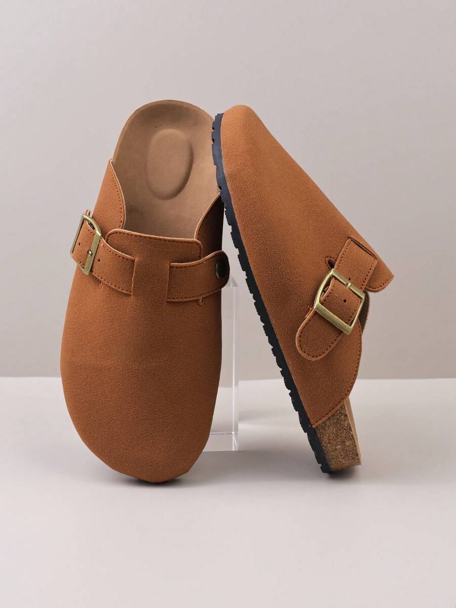 زوج من الشباشب المريحة ذات الإغلاق المعدني المزخرف من مادة الغزال الاصطناعي، برؤوس مستديرة وكعب منخفض وسميك وأرضية ناعمة، بطراز كاجوال مناسب للارتداء اليومي