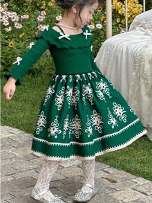 Kleine Mädchen Grünes Off-Shoulder Kleid, grünes Strickgewebe mit zarter weißer Blumen-Saum Dekoration und Schleifenakzent, vintage und verspielt, geeignet für Kinderfeste, Outdoor-Geburtstagsfeiern, Urlaub und Alltagstragen, Herbst/Winter