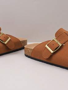 زوج من الشباشب المريحة ذات الإغلاق المعدني المزخرف من مادة الغزال الاصطناعي، برؤوس مستديرة وكعب منخفض وسميك وأرضية ناعمة، بطراز كاجوال مناسب للارتداء اليومي