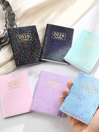 1 cuốn sổ kế hoạch A7 năm 2026 bằng chất liệu PU - Bìa họa tiết bầu trời sao hologram, bao gồm mẫu lịch trình và chi tiết lịch. Sổ tay lập kế hoạch hàng tuần/hàng ngày tối giản và hiệu quả, phù hợp cho công việc, học tập và quản lý thời gian.