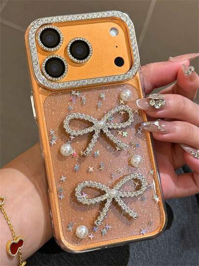 إطار كاميرا مرصع بالراين ستون 3D لامع بشريط عقدة اللؤلؤ ديكور حالة هاتف متوافقة مع 17 Pro Max 16 15 14 13 11 12 Pro Max 16 14 15 Plus 11 غطاء فني أنيق وجميل مزين بالنجوم اللامعة مقاوم للسقوط