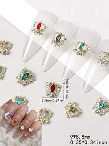 10 قطعة من إكسسوارات فن الأظافر المصنوعة من السبائك المعدنية، توفر خيارين لون كلاسيكيين: الذهبي والفضي. يأتي كل إكسسوار مع قاعدة على شكل قلب أنيق تنكسر الإضاءة عليها بشكل لامع مثل تاج مصغر. تم تصميم هذه الزينات الجمالية خصيصًا لفن الأظافر DIY، مصنوعة من مواد سبائك معدنية عالية الجودة بملمس ناعم وراق