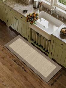 1块硅胶厨房垫，简约双色拼布图案。垫子主体为浅米色，纹理细密，类似编织，边缘为深棕色，形成清晰的区域划分。整体设计简洁大方。厨房垫风格奢华时尚，具有缓冲抗疲劳功能，表面为织物，中间为海绵吸水材质。