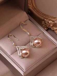 Ein Paar stilvolle und minimalistische Champagner-Perlen-Ohrringe, die einen Hauch von Luxus ausstrahlen und damit ein ideales Geschenk für einen Lieblingsmenschen oder eine Mutter sind.