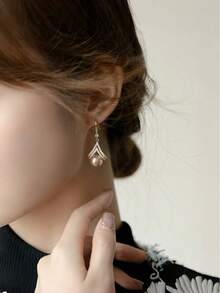 Ein Paar stilvolle und minimalistische Champagner-Perlen-Ohrringe, die einen Hauch von Luxus ausstrahlen und damit ein ideales Geschenk für einen Lieblingsmenschen oder eine Mutter sind.