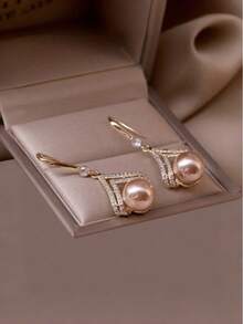 Ein Paar stilvolle und minimalistische Champagner-Perlen-Ohrringe, die einen Hauch von Luxus ausstrahlen und damit ein ideales Geschenk für einen Lieblingsmenschen oder eine Mutter sind.