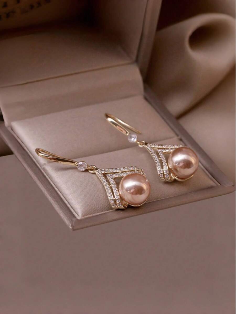 Ein Paar stilvolle und minimalistische Champagner-Perlen-Ohrringe, die einen Hauch von Luxus ausstrahlen und damit ein ideales Geschenk für einen Lieblingsmenschen oder eine Mutter sind.