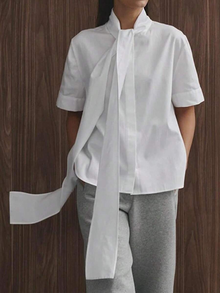 Blusa casual da donna a maniche corte, in tessuto lavorato a tinta unita, con laccio e bottoni davanti, adatta per l'ufficio e l'uso quotidiano, colore bianco estivo - Bianco - Visualizzare 1