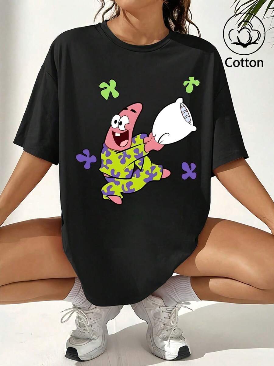 SpongeBob SquarePants Áo thun ngắn tay màu đen dáng rộng in hình hoạt hình. Hình SpongeBob mặc bộ đồ ngủ màu vàng xanh phối hoa tím, cười tươi và ôm một chiếc gối trắng. - màu đen - Xem 1