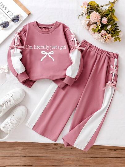 年轻女孩休闲粉色运动衫和裤子套装，带有“I'm Litally Just A Girl”字母印花和蝴蝶结装饰长袖上衣，搭配侧孔系带蝴蝶结松紧腰裤，适合日常穿着和玩耍，秋冬
