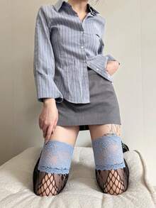 زوج من جوارب طويلة للفخذ للنساء بتصميم شبكي مزخرف بالأزهار والألوان المتباينة من الدانتيل الأزرق