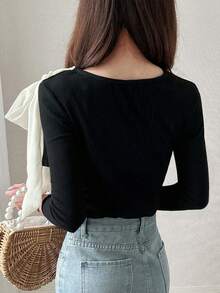 ¡Esencial coreano chic! Blusa de manga larga acanalada y ajustada en negro, con un gran lazo lateral, de moda y llamativa