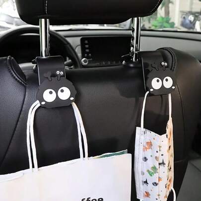 1/2 piezas Ganchos de asiento de coche con bola de carbón de dibujos animados - Accesorios de coche negros lindos para bolsos, carteras y abrigos, colgadores universales de asiento trasero de material ABS duradero