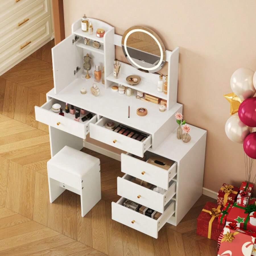 Penteadeira grande com iluminação LED ajustável (3 temperaturas de cor), tomadas integradas e espelho. Inclui um banquinho, 5 gavetas e um compartimento na porta. Cor: branco. Dimensões (L x A x P): 90 x 132 x 40 cm.