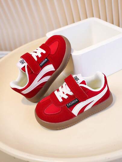 经典红白撞色皮革婴儿运动鞋，复古运动风格，带有“FASHION”品牌标识，时尚舒适，适合婴幼儿穿着。