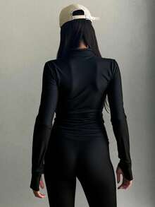 Blusa ajustada de manga larga para mujer con diseño moderno, minimalista y elegante. Prenda básica de estilo atemporal con cuello semi alto tipo mock neck, confeccionada en tela elástica y suave al tacto con acabado satinado que realza la figura y estiliza el cuerpo. Su diseño ceñido se adapta perfectamente a las curvas, brindando comodidad y libertad de movimiento. Ideal para combinar con jeans, faldas, leggins o pantalones sastre, esta blusa versátil es perfecta para outfits casuales, deportivos o urbanos. Gracias a su textura brillante y corte entallado, aporta un toque chic y sofisticado, convirtiéndose en una prenda esencial para el guardarropa femenino moderno,siendo una opción ideal para otoño, invierno o entretiempo. Perfecta para crear looks street style, sporty chic o minimalistas, se puede llevar con blazer, chaqueta, pantalones anchos o shorts. Una blusa básica pero poderosa que transmite estilo y elegancia sin esfuerzo. Inspirada en la moda coreana y europea, - Negro - Ver 1